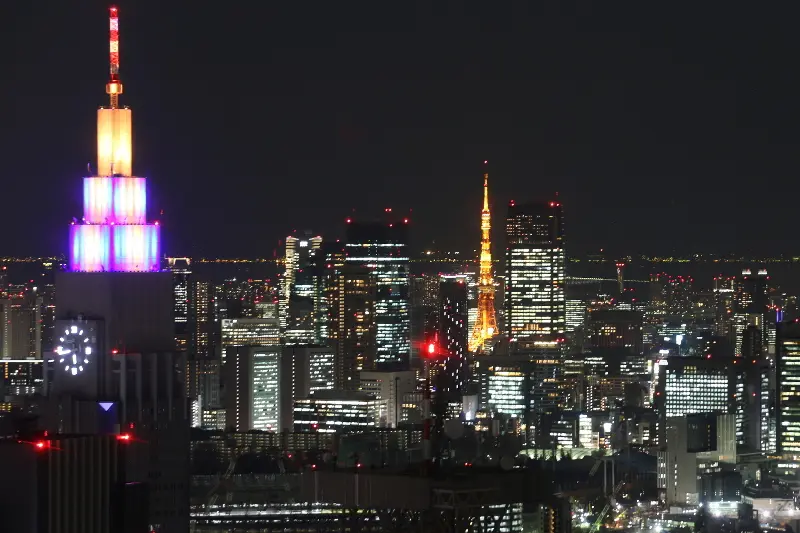 ライトアップされる東京タワーとＮＴＴドコモ代々木ビル（左側）