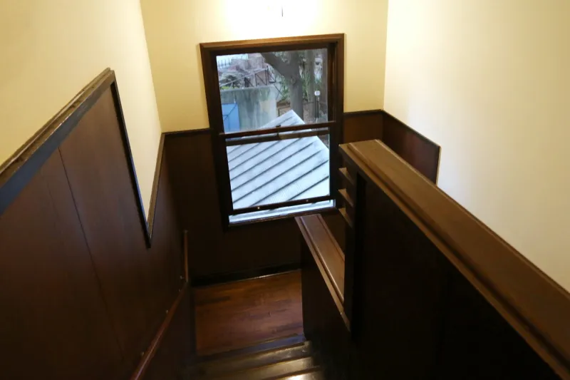 階段の踊り場に取り付けられている大きな上げ下げ窓