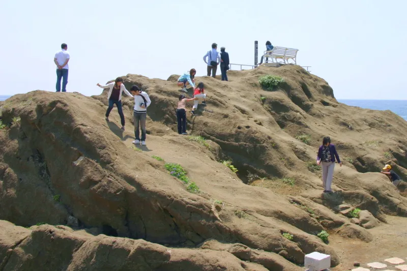 多くの人が岩場を登り景色を眺める展望スポット