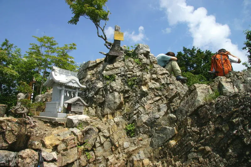 険しい岩に覆われ小さな祠の立つ両神山頂上
