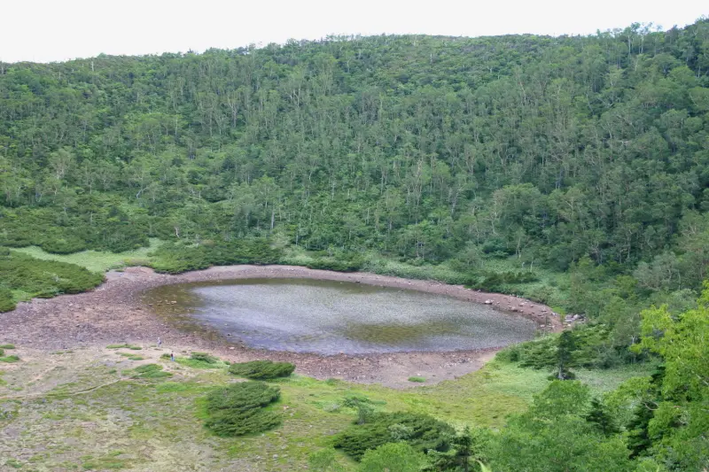 昔の噴火によって創り出された静かに水を湛える鏡池