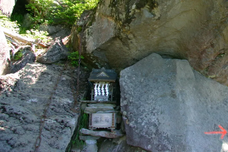 大きな岩の下に安置されている瀧尾神社の祠