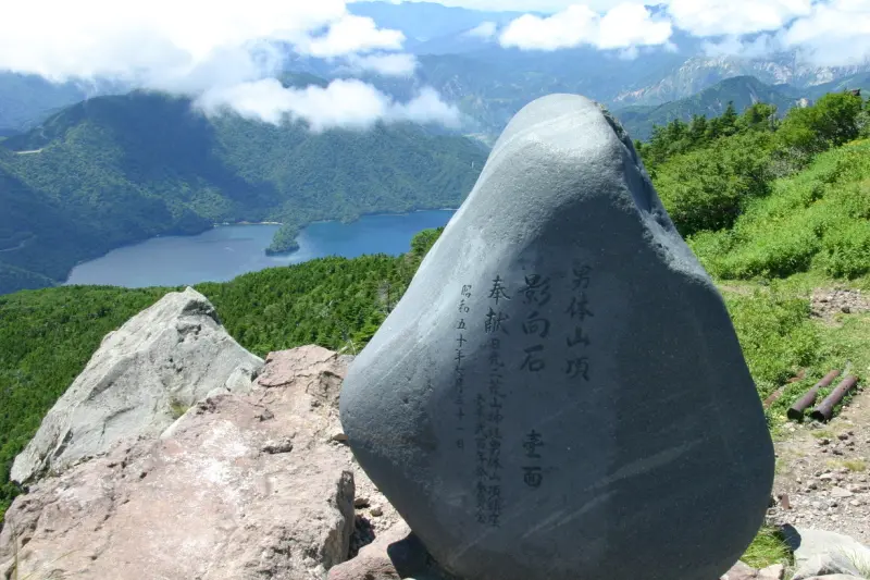 石碑が立てられ、眼下に少し湖面の見える中禅寺湖