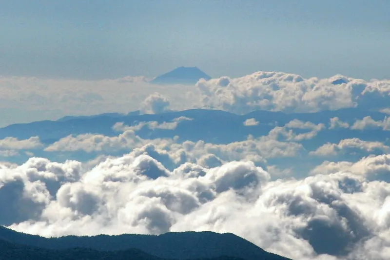 雲の上から顔をのぞかせる富士山。距離は１５０ｋｍ。