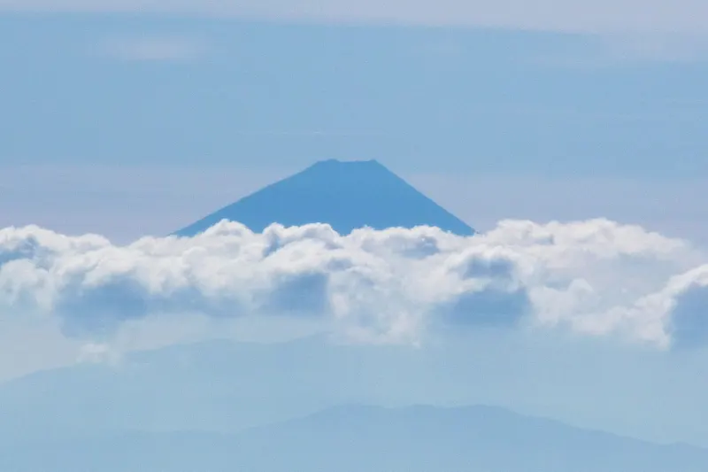 雲の上から顔をのぞかせる富士山。距離は１４０ｋｍ