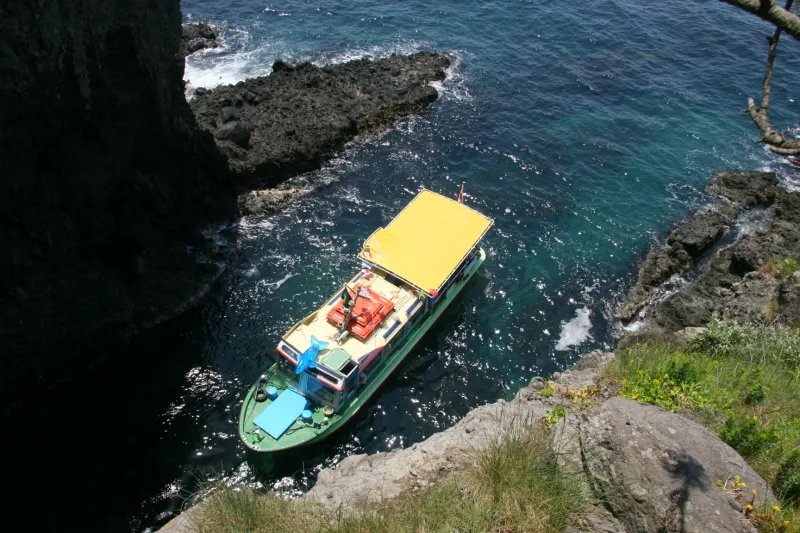 遊覧船が入っていくところを断崖の上から撮影