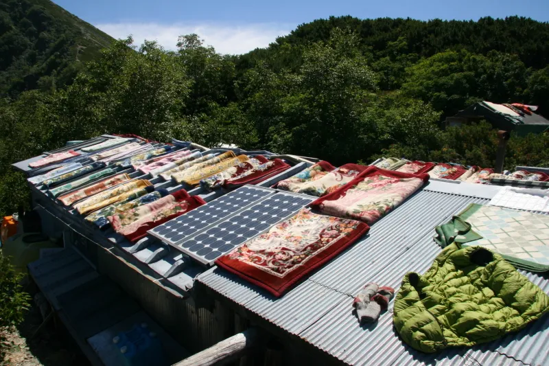 山小屋の屋根を利用した布団干し。天気も良く、のどかな光景