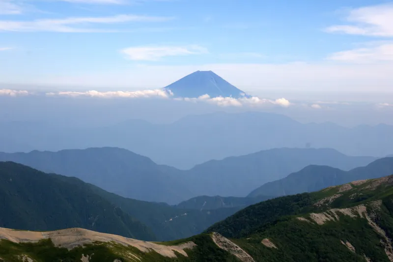 雲の上から顔をのぞかせる富士山。距離は５５ｋｍ