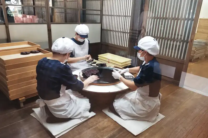 隣の部屋で見ることのできる赤福餅を一つ一つ手作業で作る職人さん