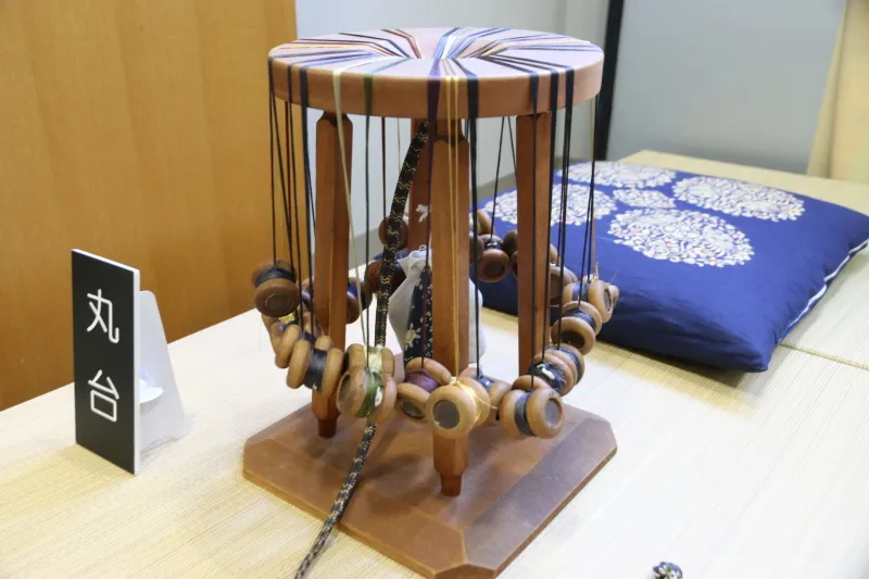 ８本の絹糸を使用して組み上げる丸台と呼ばれる専用器具