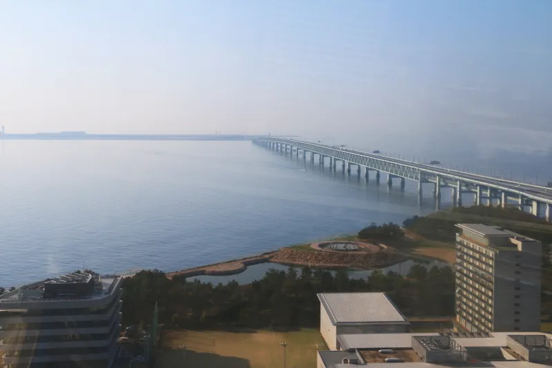 沖合へ橋が延び水平線に細長く見える関西国際空港