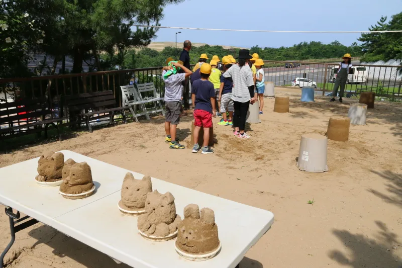 砂と水を使って砂像を造る屋外の体験コーナー