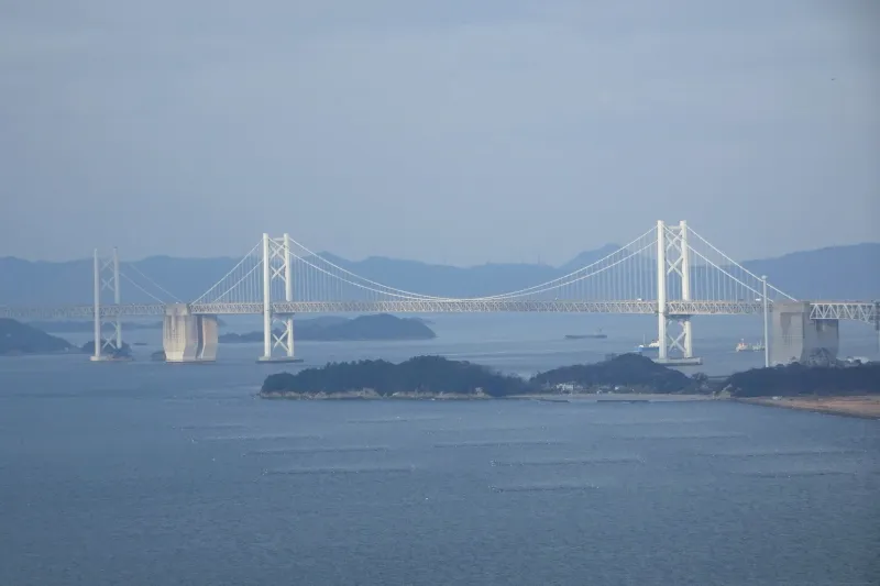 遠くに小さく見える本州と四国を結ぶ瀬戸大橋