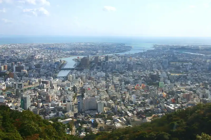 建物が立ち並ぶ中を新町川が流れ、その先に広がる海