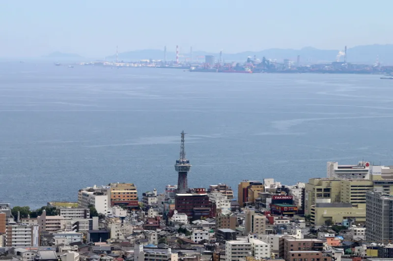 別府タワーが小さく見られ、海の向こうは日本製鉄九州製鉄所