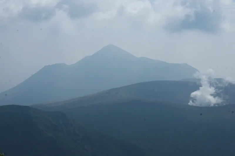 ８ｋｍ先にそびえ立つ高千穂峰。右端の煙は新燃岳の噴煙