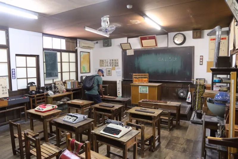 木造の小さな机が並べられている小学校の教室 