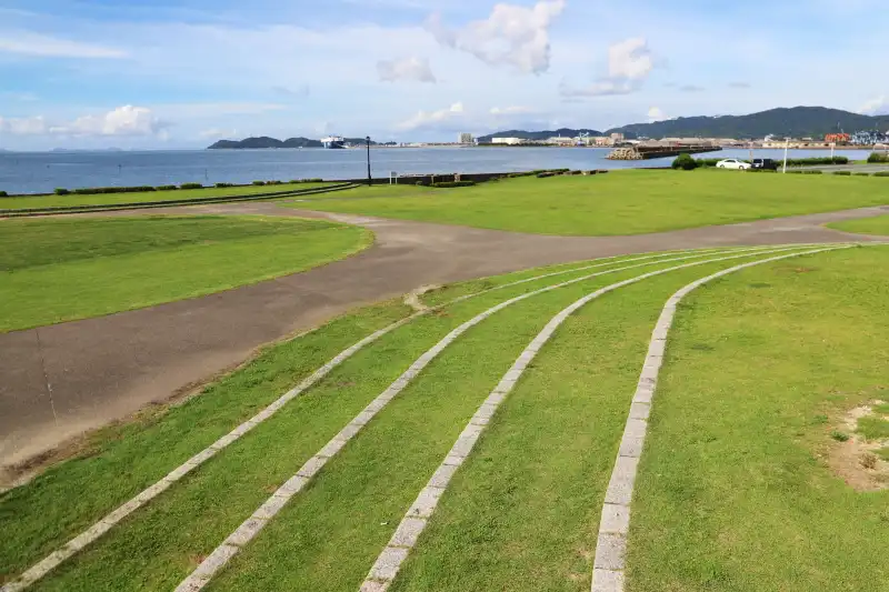 海岸沿いに芝生広場が広がっている竹島園地