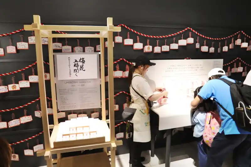 今年漬けた梅干しを25年後にもらえる、万博漬け引換券を配布するコーナー