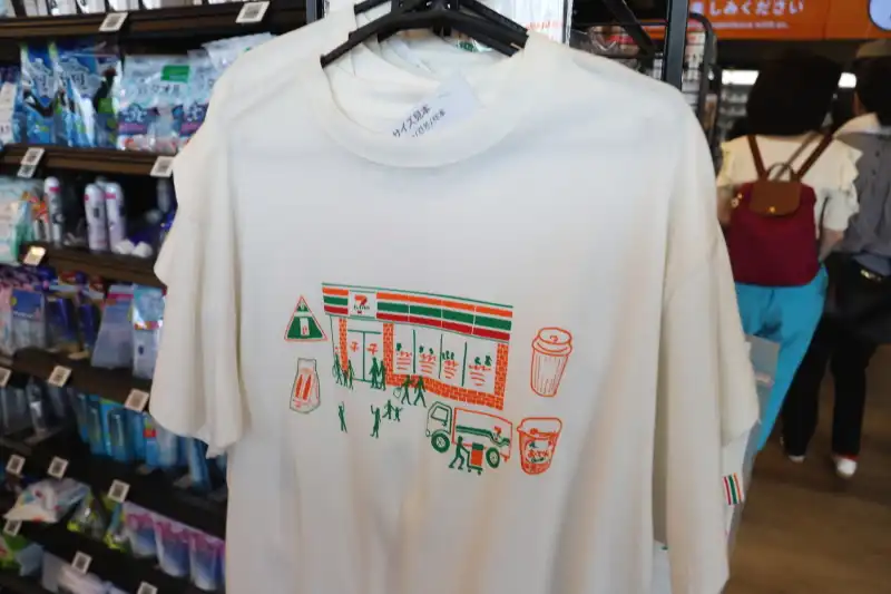 セブンイレブンのお店をユーモアに描いた、万博限定販売のパックTシャツ