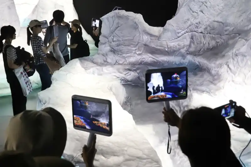 白い氷河にタブレットを向けると仮想世界が表示されるAR体験