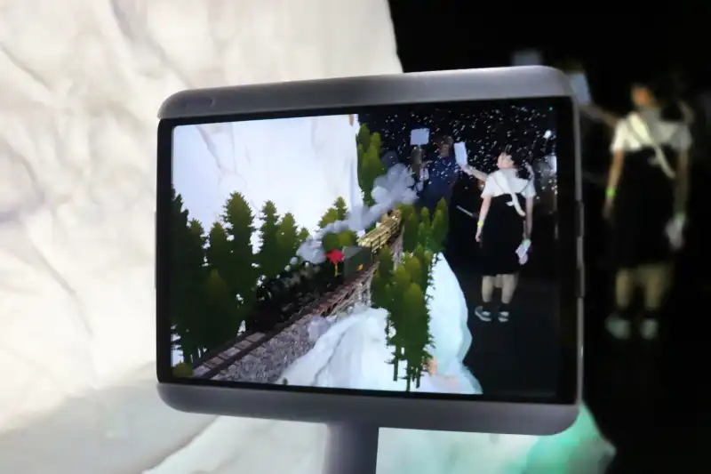 人が画面に映り込む横を蒸気機関車が通り過ぎる不思議な世界