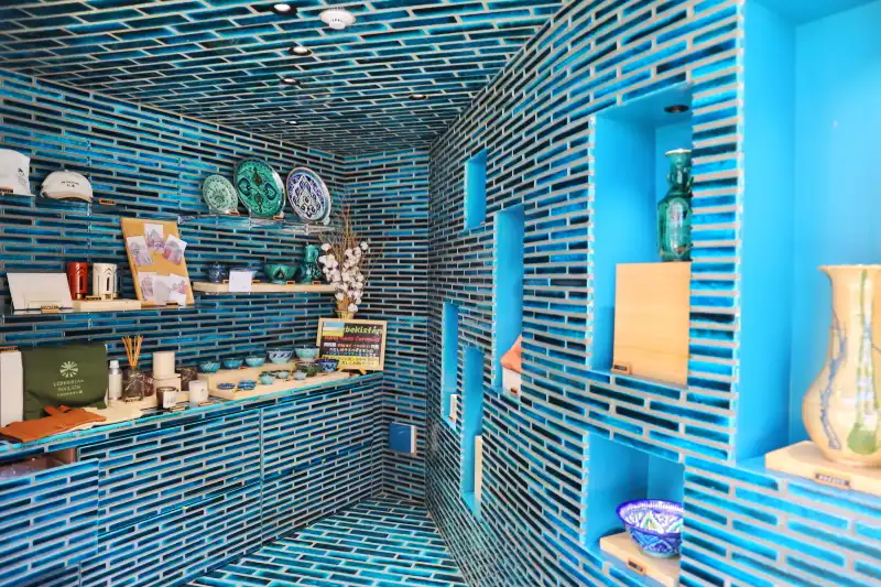 青いタイルが床や壁に敷き詰められたオフィシャルショップ